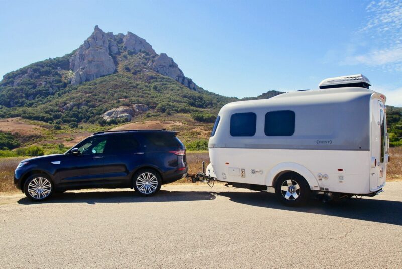 Small travel trailer being towed by an SUV