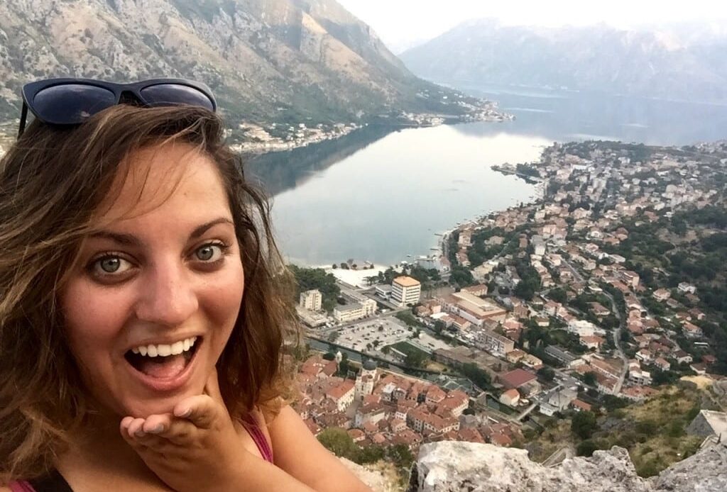 Kate takes a selfie at sunrise in front of the Bay of Kotor