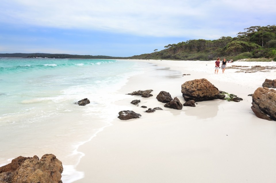 Tourists or holiday makers enjoy the white sands and aqua waters of Hyams Beach Jervis Bay Australia