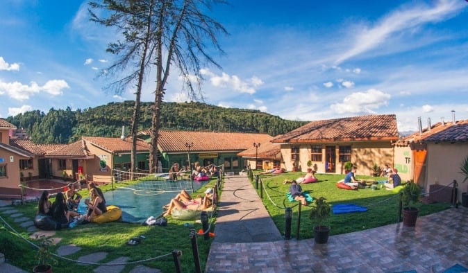 Expansive garden area with people playing yard games and lounging at Wild Rover, a hostel in Cusco, Peru