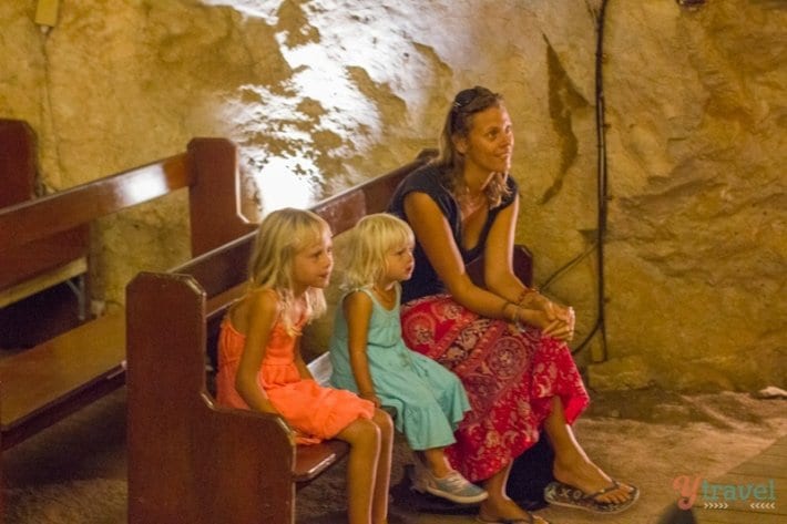 people sitting in a church inside a cave