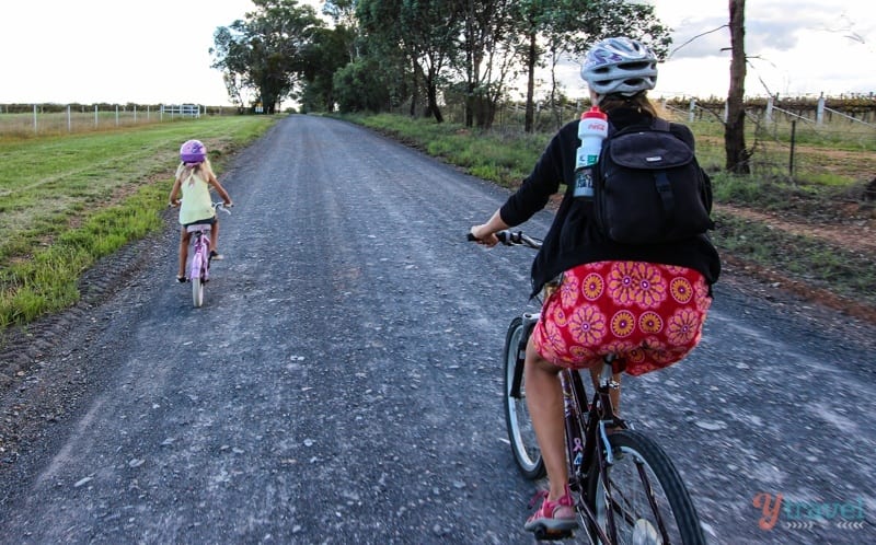 woman and child cycling down country road