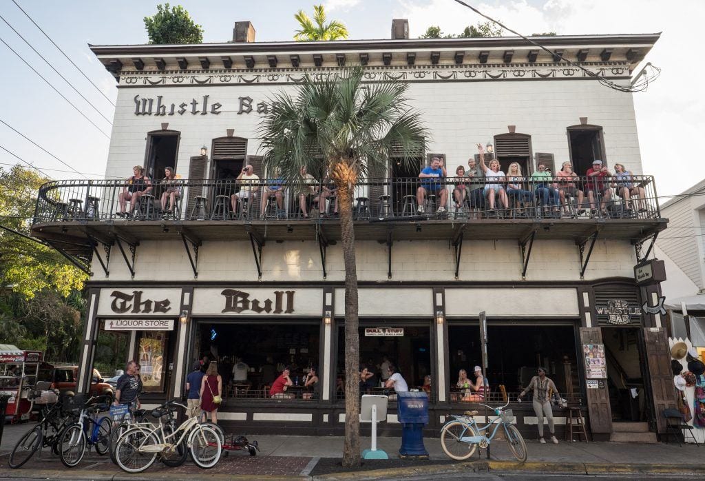 The Bull, a bar on Duval Street with people sitting out on the balconies and waving to the camera.
