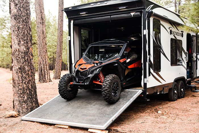 Camper toy hauler with the garage door down and a UTV parked inside -