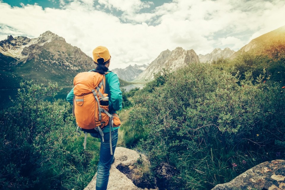 young backpacking woman hiking in the nature