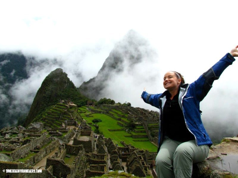 woman posing with arms outstretched in front of Machu Picchu