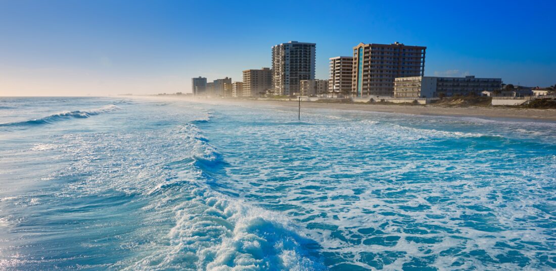 Shore Buildings and wavy beach water at Daytona Beach in Florida. 