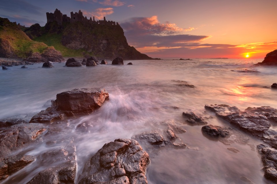 The ruins of the Dunluce Castle on the Causeway Coast of Northern Ireland. Photographed at sunset.