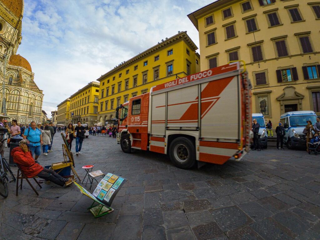 Dynamic Street Scene with Fire Engine at Santa Maria Del Fiore, Florence, Italy - Vigili del Fuoco firetruck in action amid historic city life