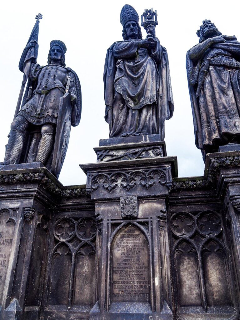 Prague's Charles Bridge Gothic statues against atmospheric skies