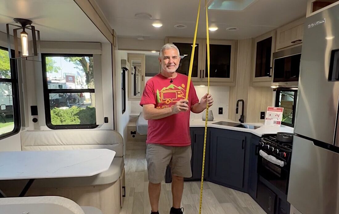 Mike from RVBlogger measuring the ceiling height of an RV camper with his tape measure
