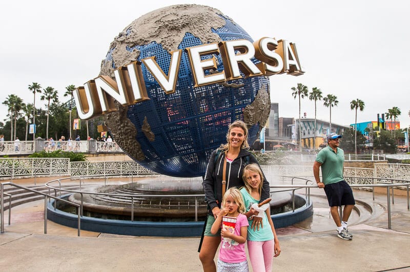 mother and two daughters outside universal orlando logo
