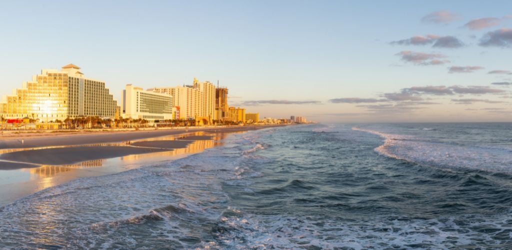 Daytona Beach, Florida. A view of a beautiful sandy beach during a vibrant sunrise. 
