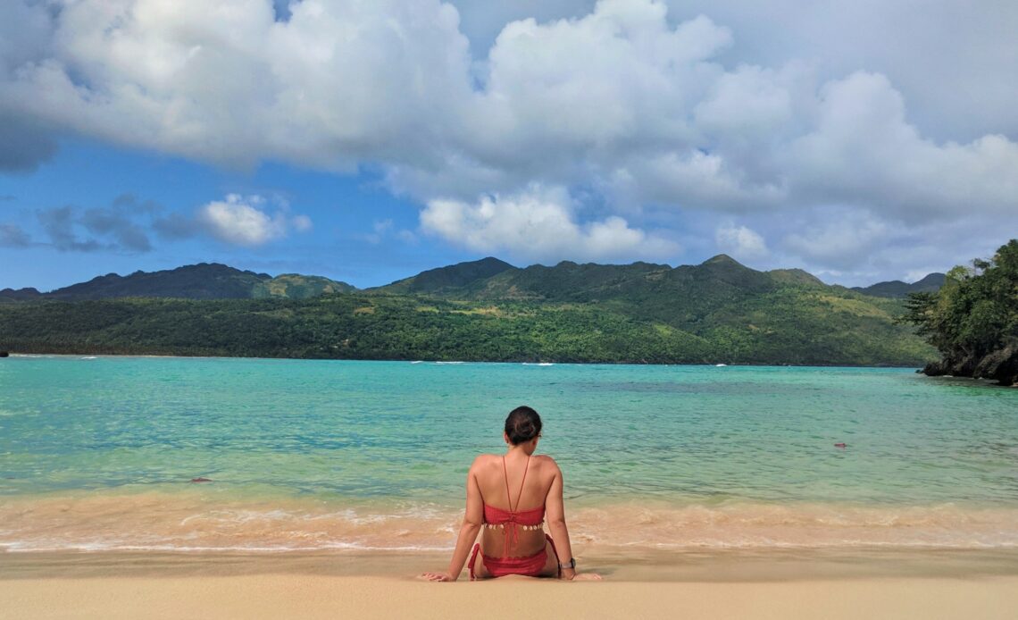 Woman sitting on the beach in Las Galeras, Dominican Republic (photo: Michael Baron)