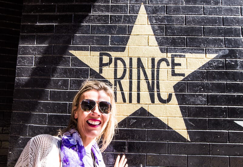 woman in front of Prince Star on outside wall of First Avenue, Minneapolis