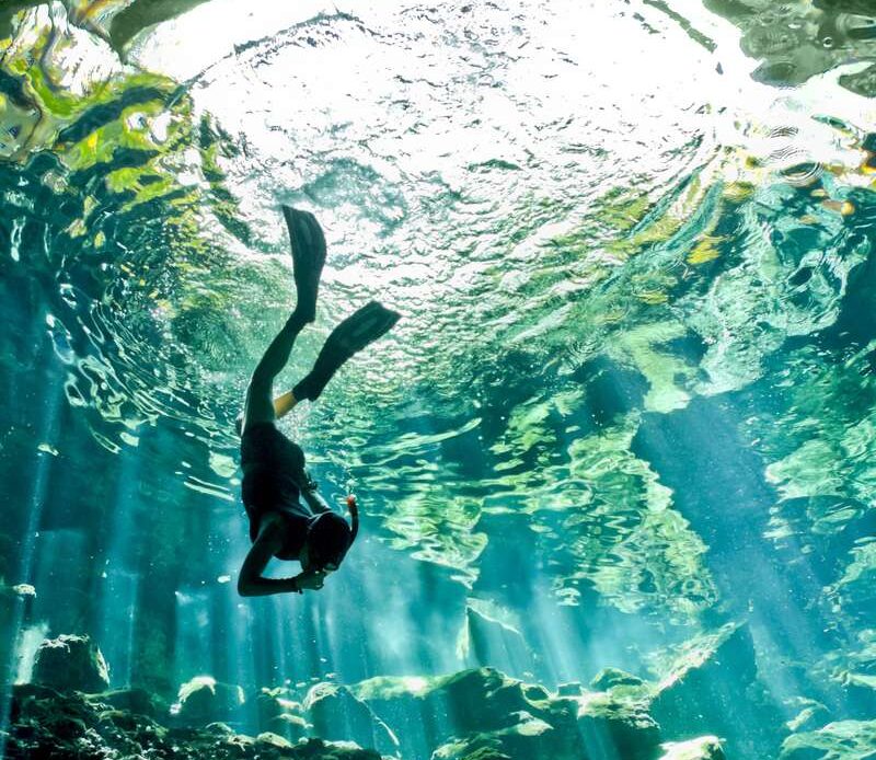 Gran Cenote Tulum Mexico a Woman swimming underwater