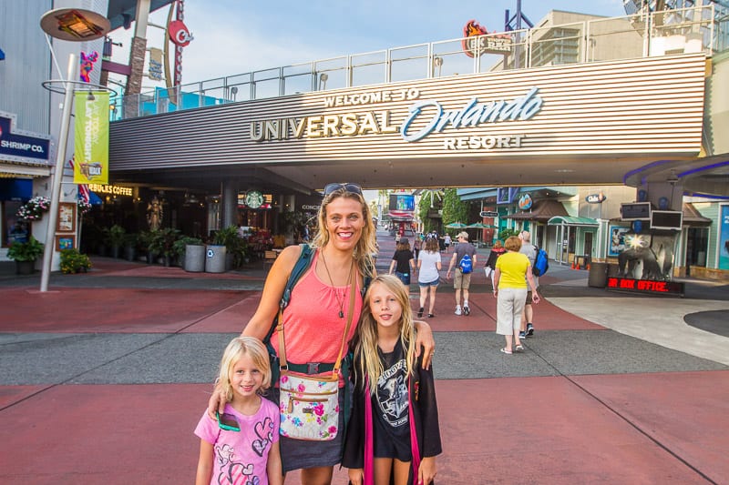 woman and two girls posing in front of universal orlando resort entrance