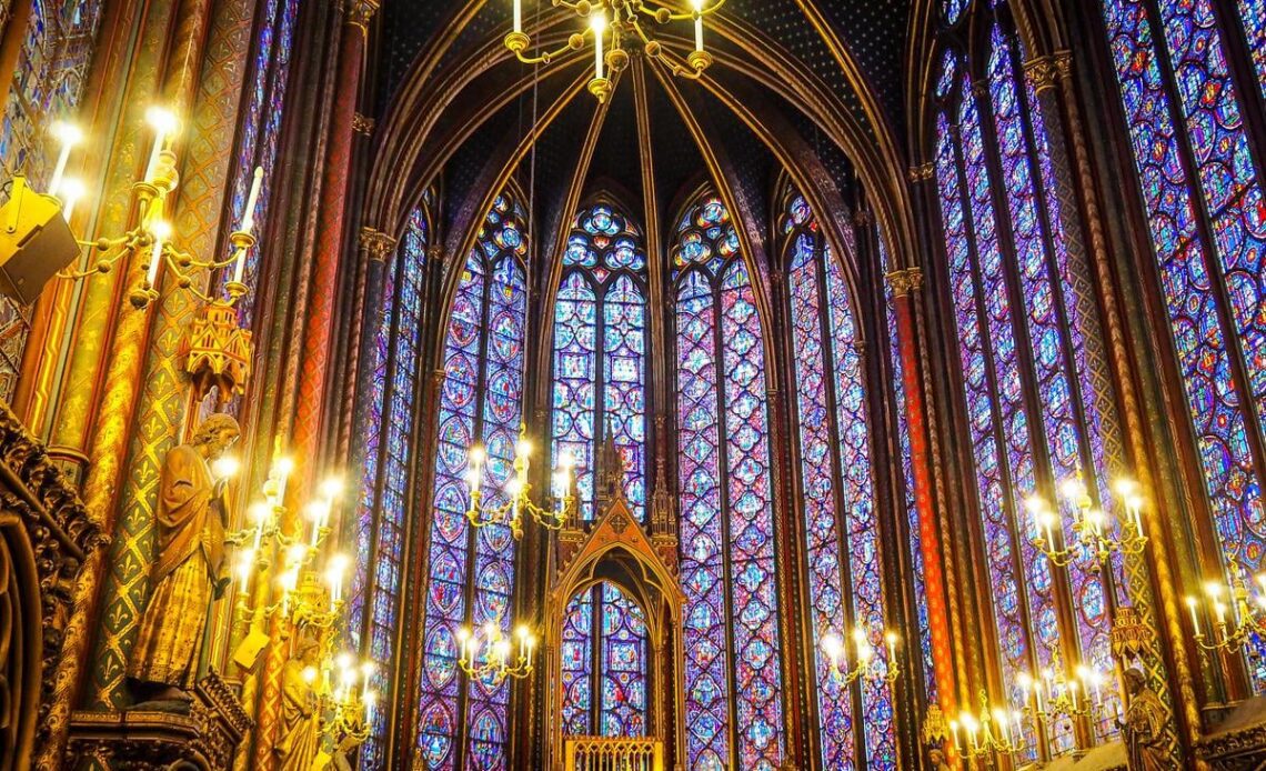 Luminous stained glass windows and Gothic details inside Sainte-Chapelle, Paris.