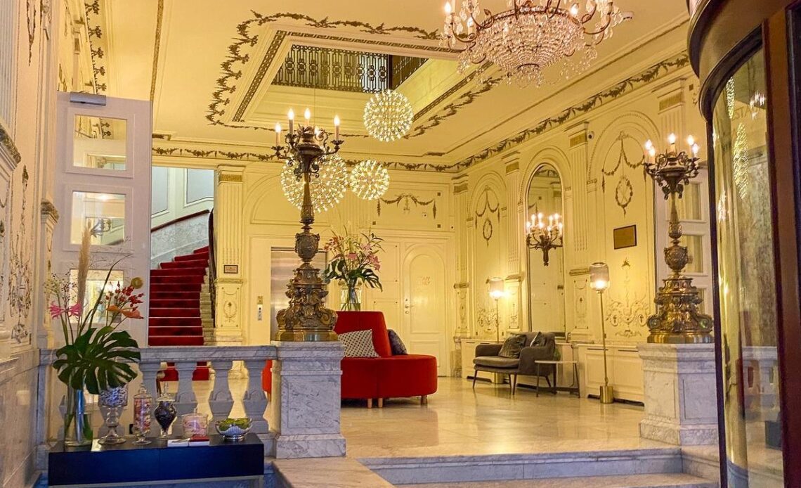 Luxurious Tivoli Doelen Amsterdam Hotel lobby with grand staircase and chandeliers