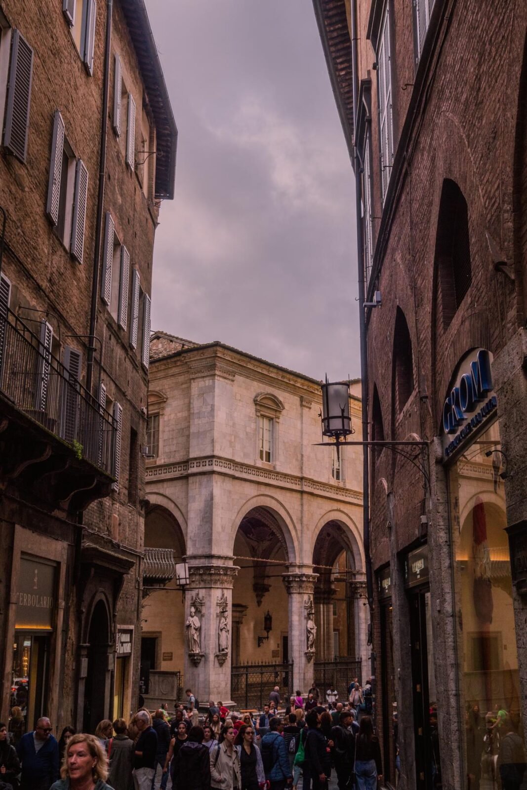 Busy street scene in Siena Italy at twilight