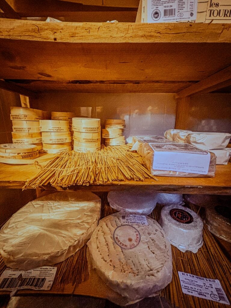 Artisanal cheese aging process in traditional Parisian fromagerie, showcasing a variety of carefully aged cheeses on wooden shelves.