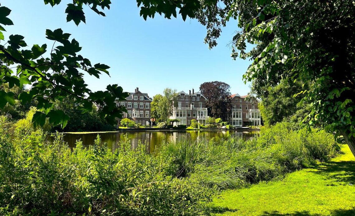 Vondelpark scenery with greenery, calm waters, and Dutch architecture