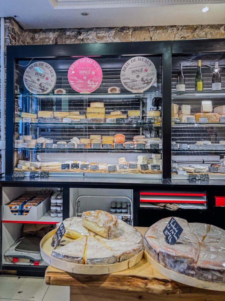 Artisanal cheese aging process at Paroles de Fromagers in Paris, France, showcasing various stages of cheese maturity, French cheeses, wine pairings, and traditional aging techniques.