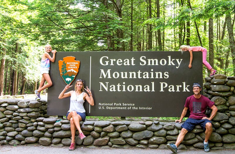 family posing in front of great smoky mountains national park sign