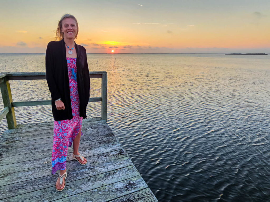 woman on pier in front of sunset in duck nc
