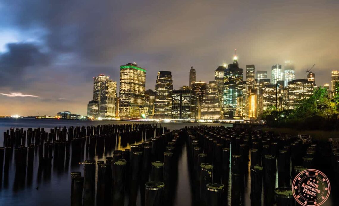 new york skyline lit up at night across the bay