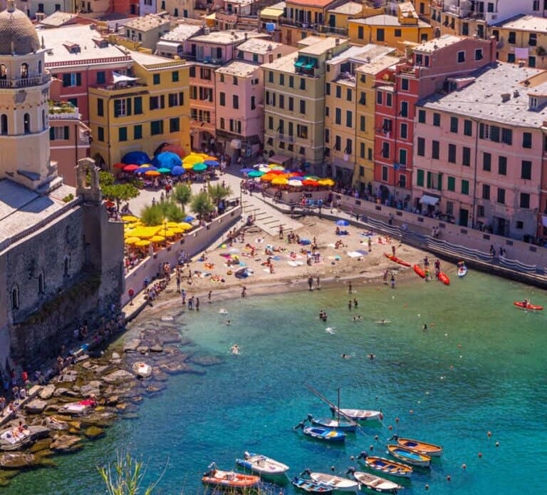 overlooking colorful buildings of vernazza and small harbor beach