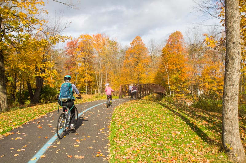 family riding bikes  on the Stowe Recreation Path in the fall