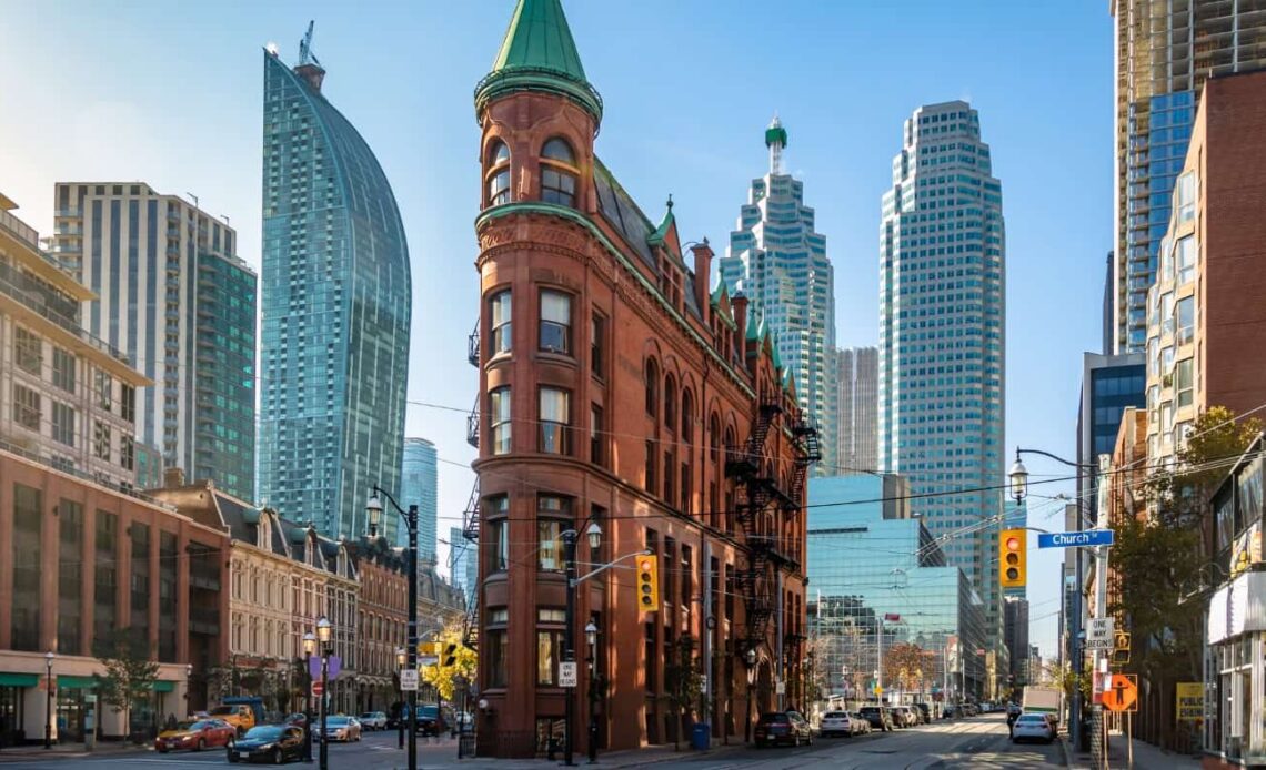 Streetscape in Toronto, Canada, showing the iconic flatiron building and other skyscrapers in the background