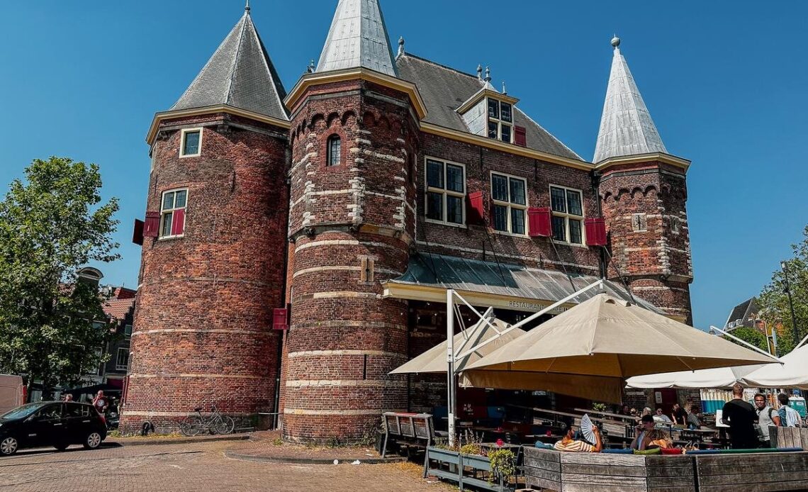 Historic De Waag building in Amsterdam, showcasing medieval architecture and bustling market scene