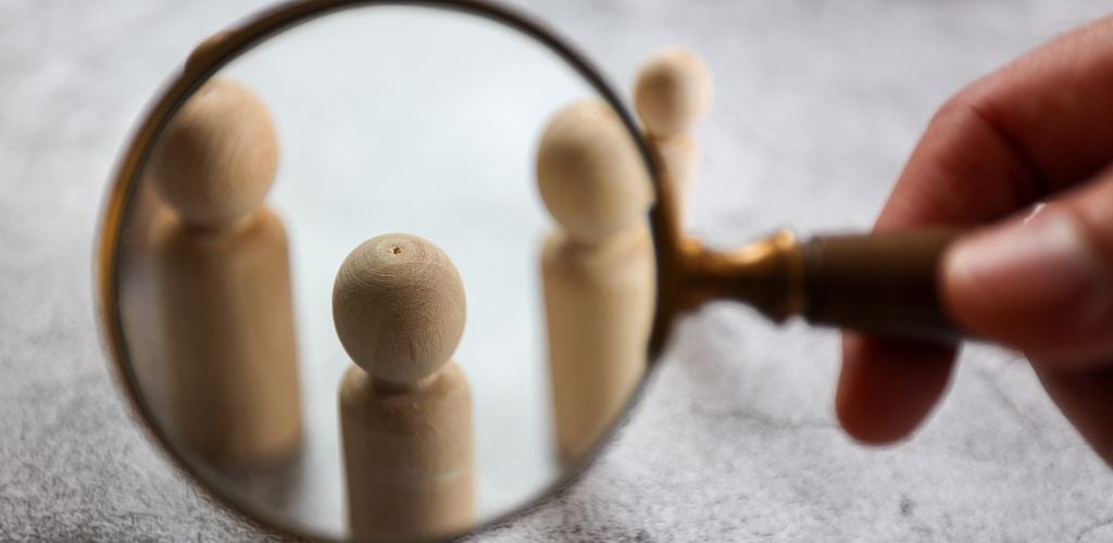 target audience represented by magnifying glass in front of wooden pins