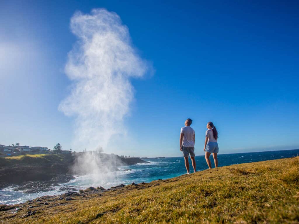 Couple watching the water plume from the Kiama blowhole.
