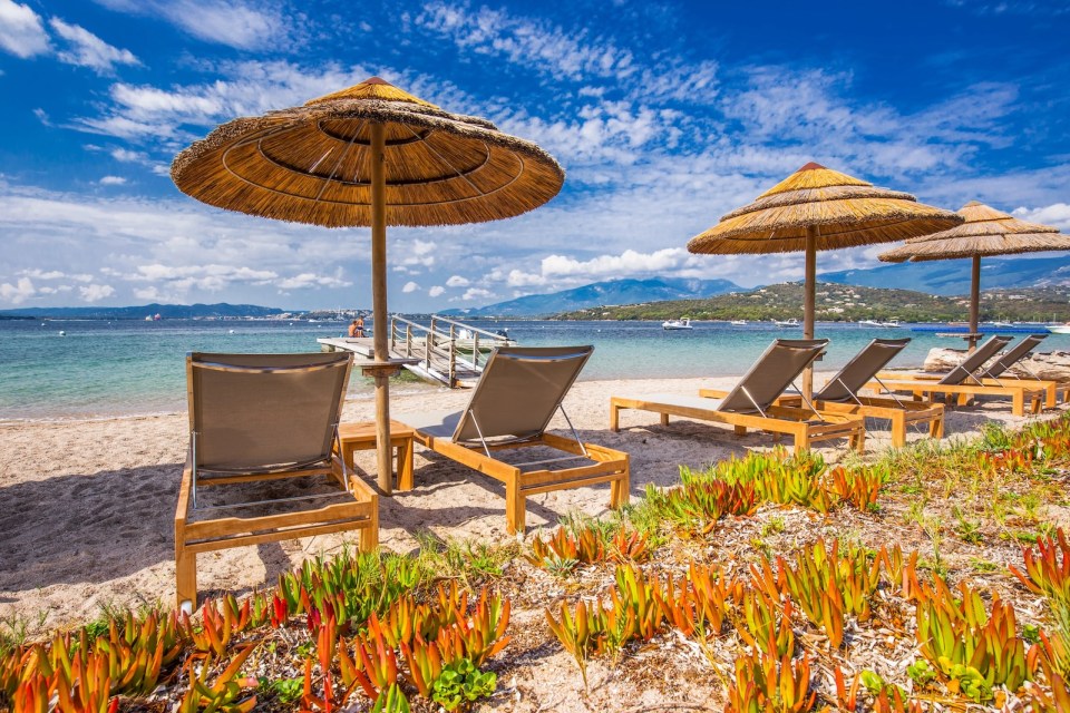 Beach chairs with a white sandy beach in Corsica, France, Europe