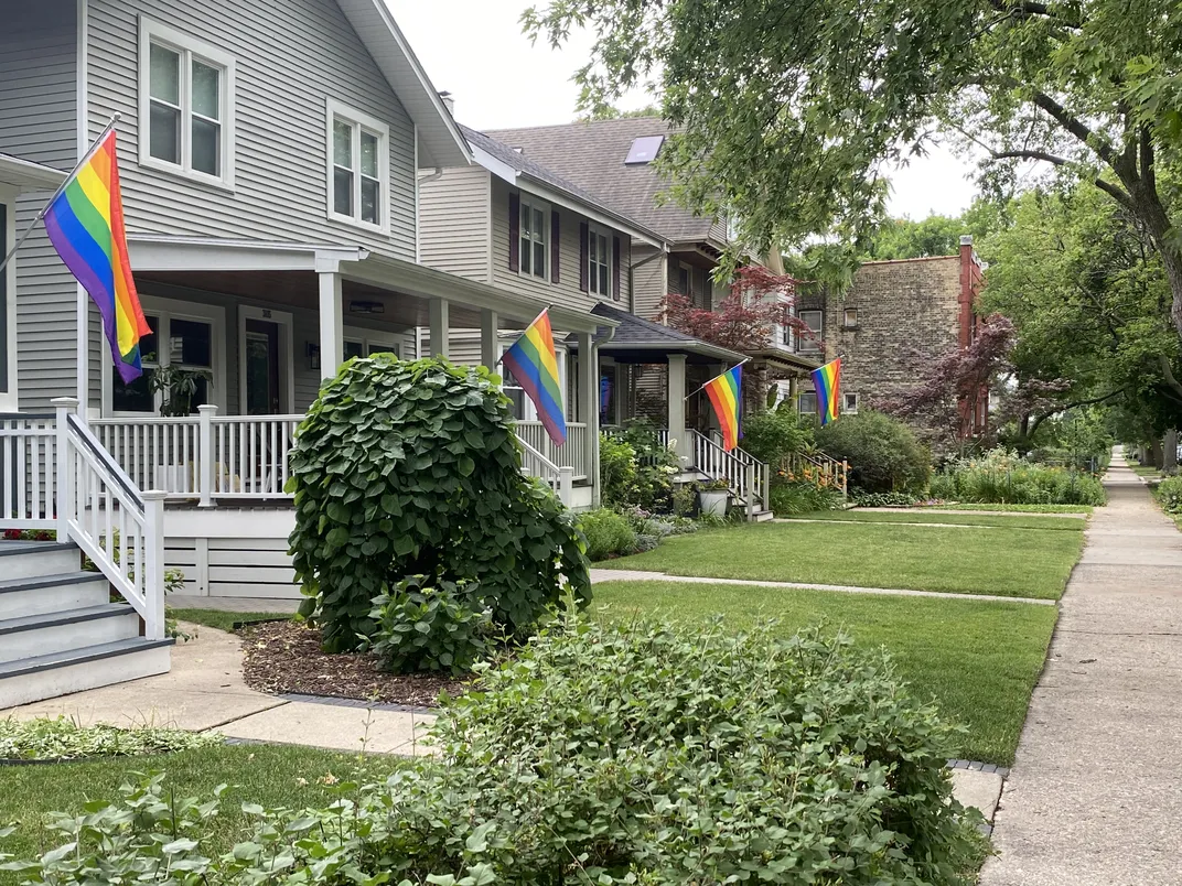 rainbow flags line a row of homes
