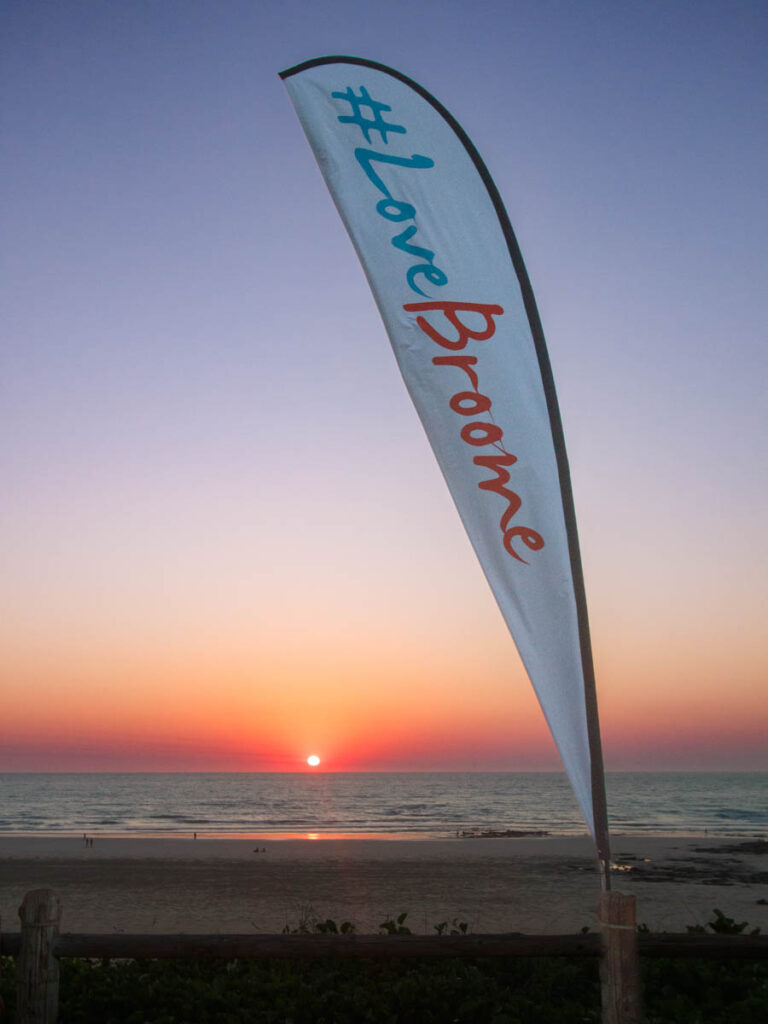 flag that says i love broome with beach sunset behind