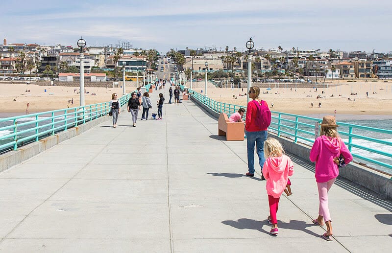 family walking on pier of Manhattan Beach, California