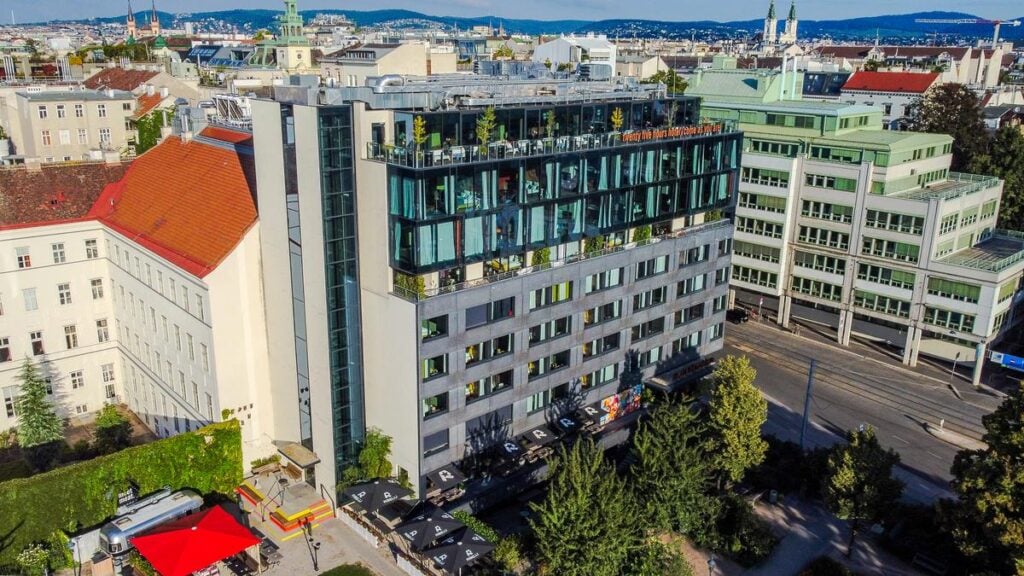 Aerial view of 25hours Hotel Museumsquartier's modern design and Vienna cityscape.