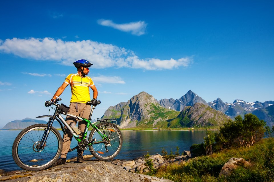 Biking in Norway against picturesque landscape. Bike, active.