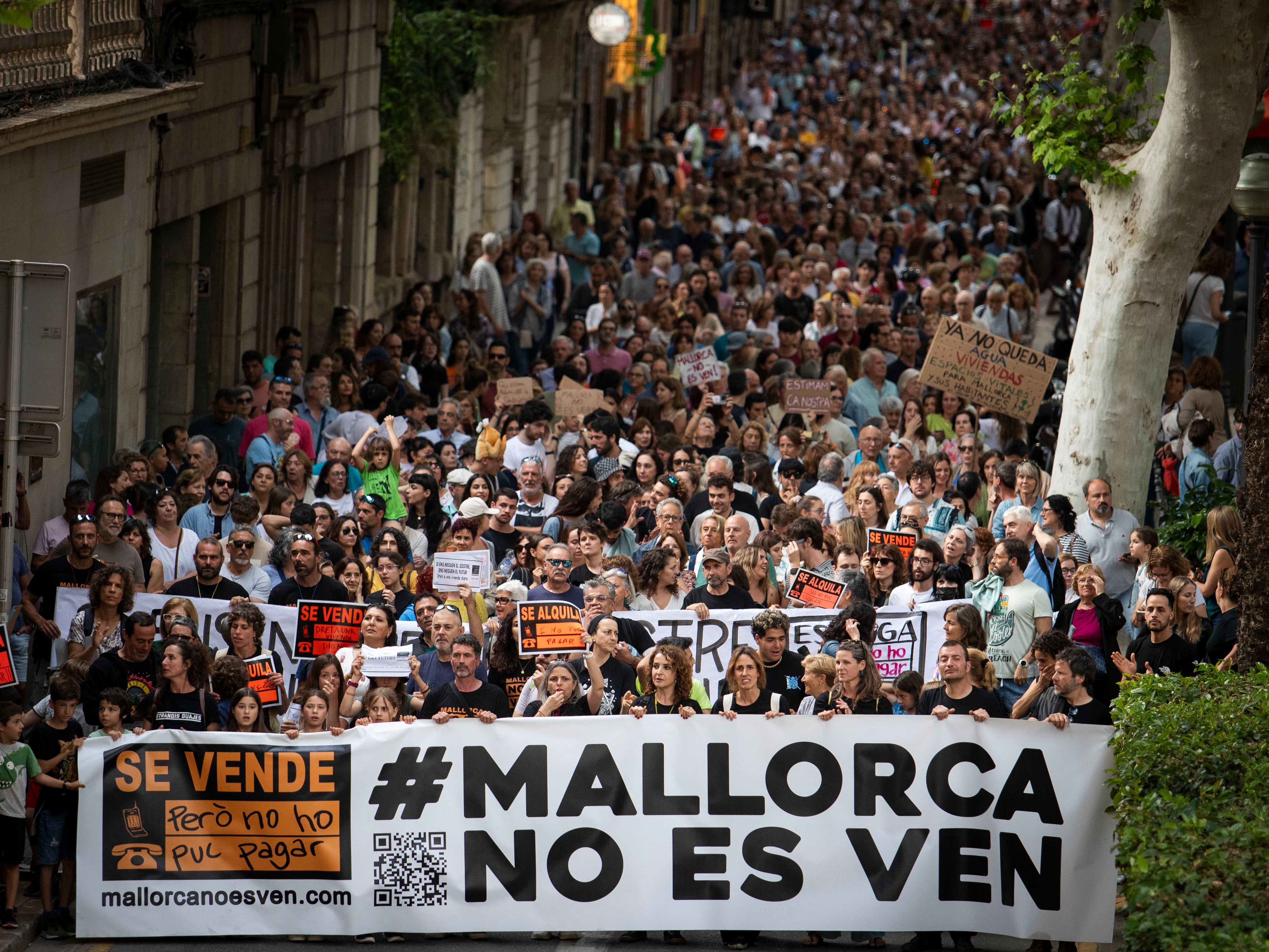 Protesters hold a banner reading “Mallorca is not for sale”