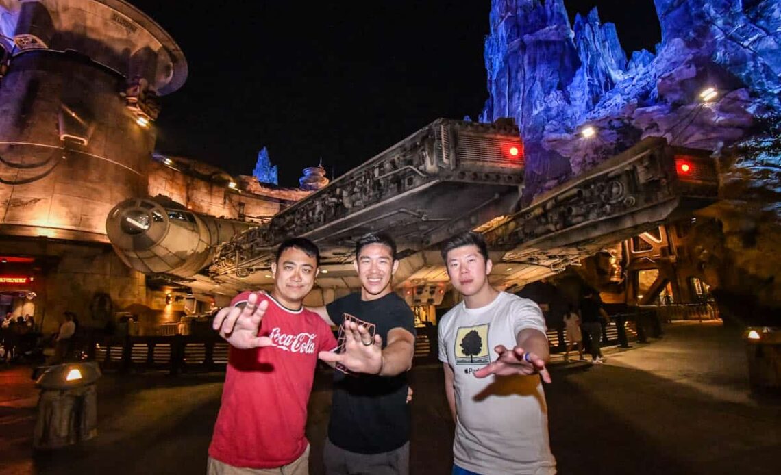 3 adults using the force pose at disneyland using the photopass in galaxy's edge