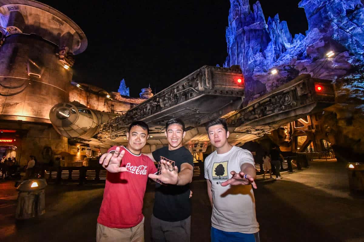 3 adults using the force pose at disneyland using the photopass in galaxy's edge