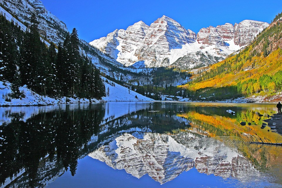 The snow capped peaks of the Maroon Bells reflects in Marron Lake near Aspen Colorado.