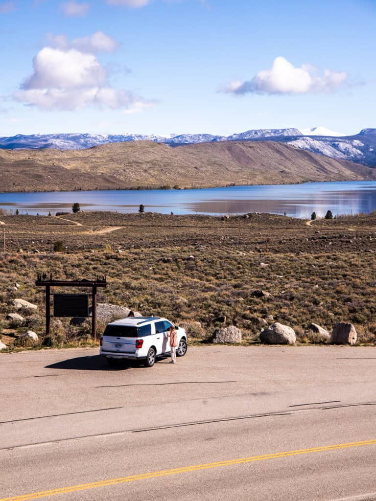 Car at a rest stop overlooking a lake.