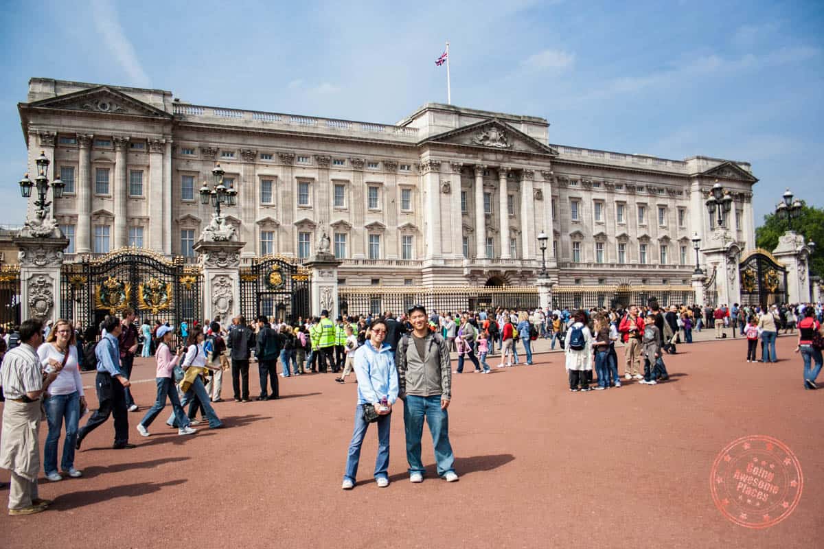 standing in front of the buckingham palace