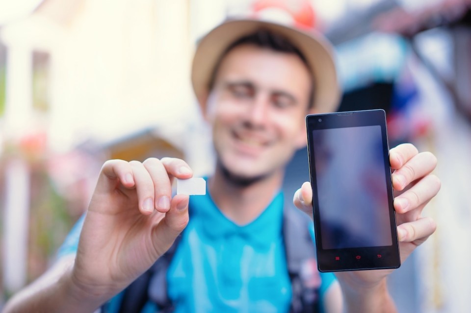 Young traveler showing sim card