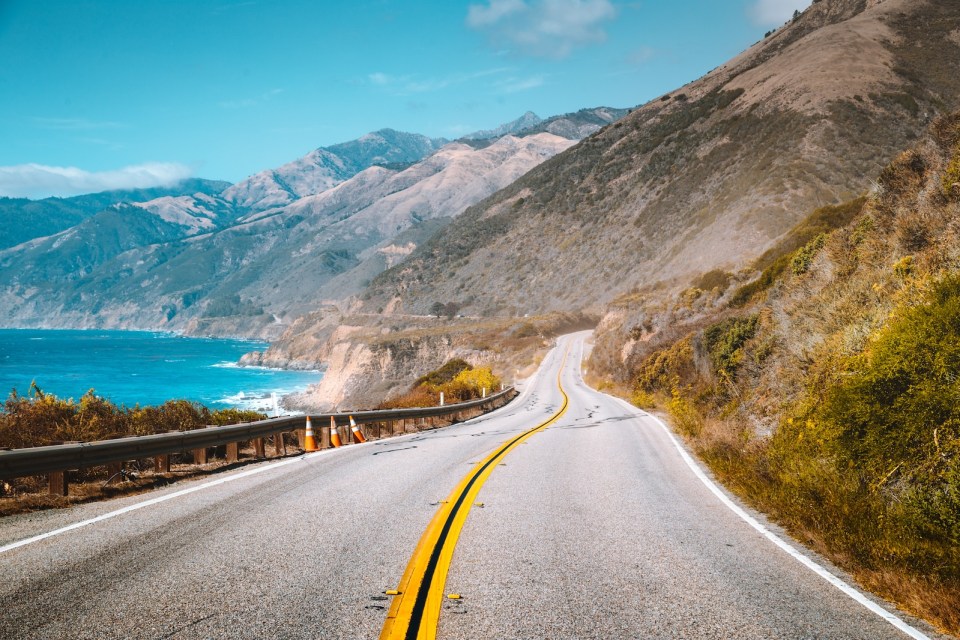 Scenic view of world famous Highway 1 with the rugged coastline of Big Sur in beautiful golden evening light at sunset in summer, California Central Coast, USA